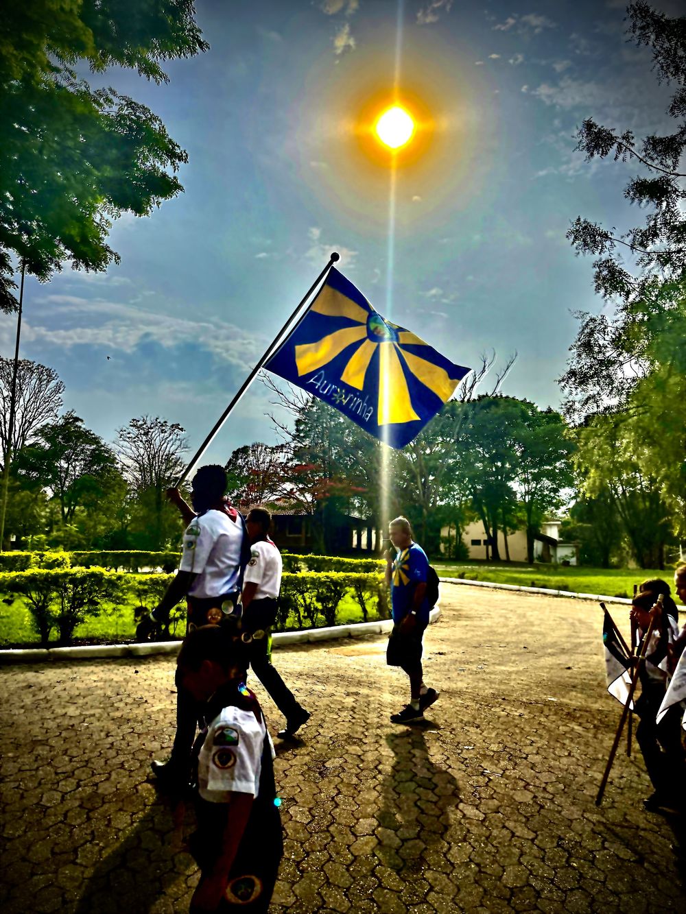 Bandeira do Aurorinha erguida contra o sol durante o Aventuri
